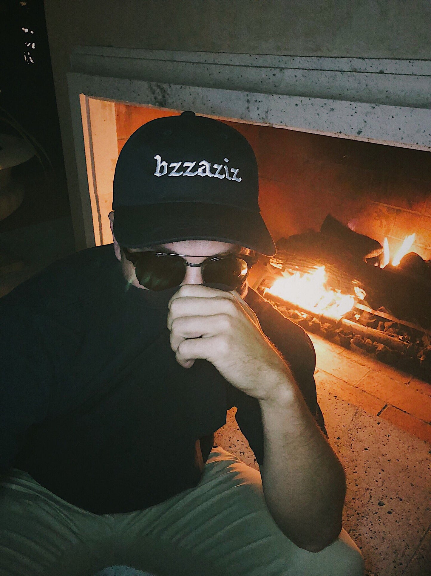 Bug mane wearing a black hat that says bzzaziz covering his face