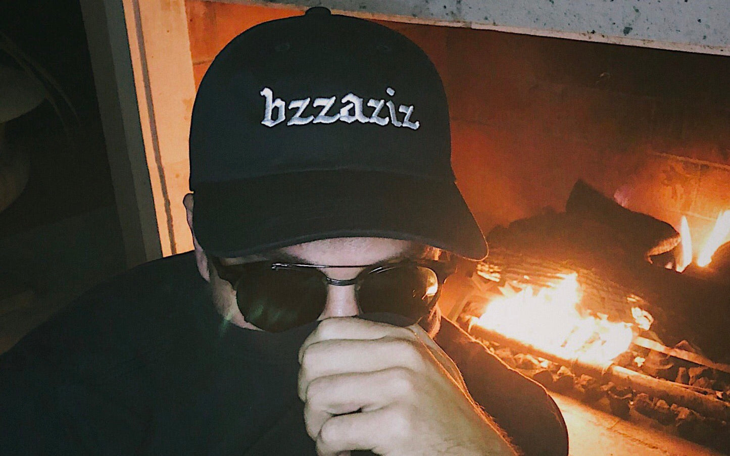 Bug mane wearing a black hat that says bzzaziz covering his face