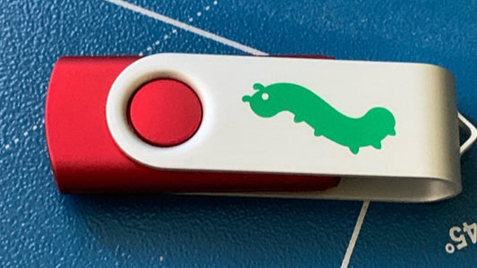 red USB drive with Bug Emoji symbol printed on it