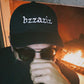 Bug mane wearing a black hat that says bzzaziz covering his face